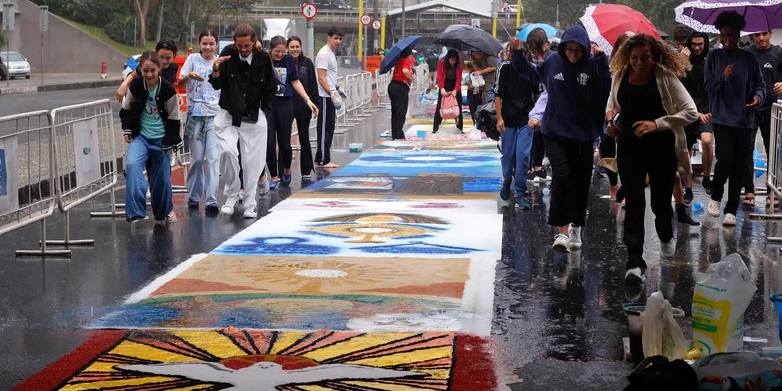 Fiéis enfrentam chuva para fazer tapetes de Corpus Christi no